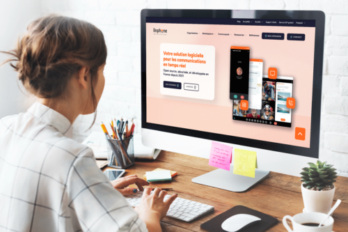 Une femme devant son ordinateur est en train de consulter le nouveau site web Linphone.